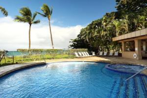 una piscina con palmeras y el océano en Paki Maui 313, en Kahana