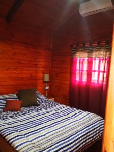 1 dormitorio con cama y ventana roja en La Beatriz en San José