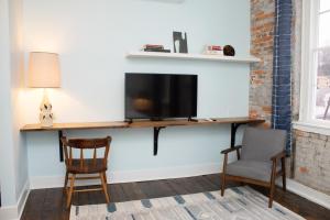 a living room with a tv and two chairs at Bischoff Inn - Former 1870 Furniture Factory Now 5 Room Boutique Hotel 