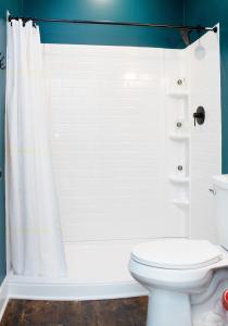 a bathroom with a white shower curtain and a toilet at Bischoff Inn - Former 1870 Furniture Factory Now 5 Room Boutique Hotel 