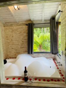 a bath tub in a room with a window at Chalé Recanto dos Pinheiros in Monte Verde