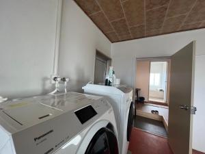 a white washing machine in a room with a window at HOSTEL OE in Yoshinogawa