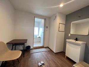 a small bathroom with a sink and a table at HOSTEL OE in Yoshinogawa