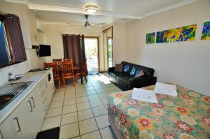 a kitchen and a living room with a bed and a couch at Cape Hillsborough Nature Tourist Park in Seaforth