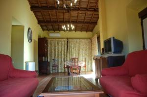 a living room with two red couches and a tv at Casa Rural Sietevillas Padel in Villasbuenas de Gata
