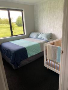 a bedroom with two beds and a window at Beautiful Home with Rural Views in Kihikihi