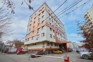 Un edificio alto con coches aparcados en un estacionamiento. en Cozy 3 Bedroom Apartments In Centre of Iasi Palas Mall, en Iaşi