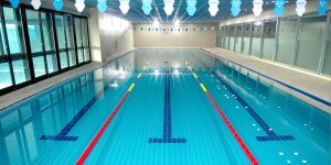 a large swimming pool with lanes in a building at Interburgo Hotel Wonju in Wonju