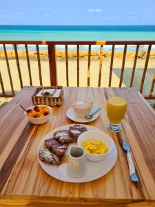 Intiquilla Hotel في مانتا: طاولة مع طبق من طعام الإفطار وإطلالة على الشاطئ
