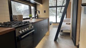 a kitchen with a stove top oven next to a window at Micro maison le Nordik in Saint Zenon +29 photos