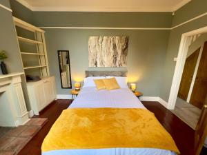 een slaapkamer met een groot bed en een gele deken bij Stylish 4 bed house with parking in central Norwich in Norwich