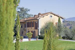 une grande maison avec un jardin en face de celle-ci dans l'établissement Relais Villa Belvedere, à Incisa in Valdarno