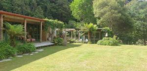 una casa con porche y patio en Blackfern Lodge, en Waimiha