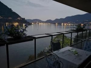 a view of a lake from a balcony with a table at Lakeviewcabin - King Room With Balcony in Como