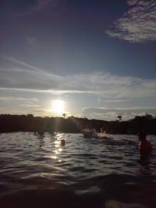 grupa ludzi w wodzie o zachodzie słońca w obiekcie Resort Quinta Santa Barbara 18 a 24 Agosto w mieście Pirenópolis