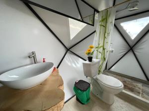 ein Badezimmer mit einem weißen Waschbecken und einem WC in der Unterkunft Glamping de Lujo Suesca Montemoral in Suesca