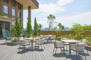 un patio con mesas y sillas en un edificio en Citadines Connect Rochester Singapore en Singapur