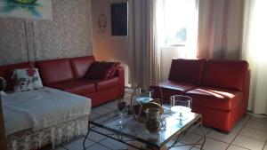 una sala de estar con 2 sofás rojos y una mesa. en Apart Hotel Ilha Residence, en Florianópolis