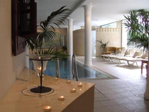 a lobby with a pool in a building with candles at Hotel Annabell in Merano