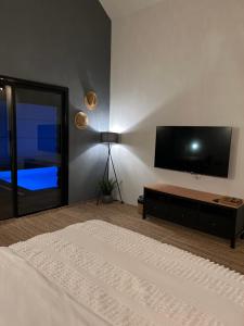 a bedroom with a flat screen tv and a bed at شاليه كوتج in Buraydah