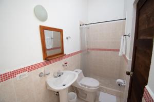 y baño con lavabo, aseo y espejo. en Hotel Villa Luna, en Villa de Leyva