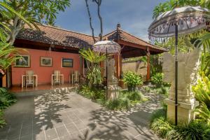 a house with a patio and a building at Tebesaya Cottage by Pramana Villas in Ubud