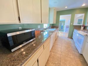 a large kitchen with white cabinets and blue appliances at WHOLE Family - Edison in Sacramento
