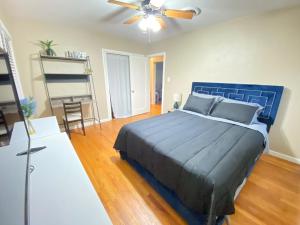 a bedroom with a blue bed and a ceiling fan at WHOLE Family - Edison in Sacramento