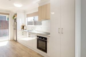 uma cozinha branca com armários brancos e uma janela em Hummingbird Apartments 4264 Tor em Rockville