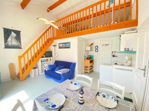 een woonkamer met een blauwe bank en een trap bij Maison Bretignolles-sur-Mer, 2 pièces, 4 personnes - FR-1-231-267 in Brétignolles-sur-Mer