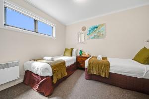 a bedroom with two beds and a window at Jasper 4 in Jindabyne