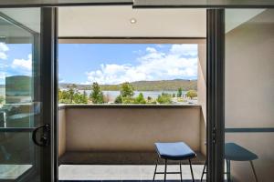 a blue stool sitting in front of a window with a view at Jasper 4 in Jindabyne