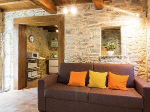 un sofá en una sala de estar con una pared de piedra en Belvilla by OYO Holiday home with garden en Pian dʼOrsina