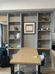 une table en bois dans une chambre avec des étagères dans l'établissement Luxury Apartemen Grand Lagoon Sungkono Surabaya, à Dukuhpakis