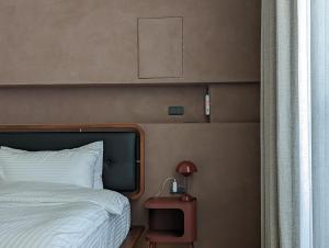 a bedroom with a bed and a table with a lamp at Kun living in Taitung City