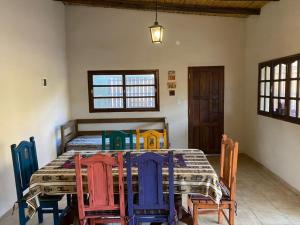 a dining room with a table with colorful chairs at Casa de alquiler - La Soñada de Tilcara in Tilcara