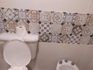 a bathroom with a toilet and tiles on the wall at Casa de alquiler - La Soñada de Tilcara in Tilcara