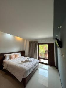 een slaapkamer met een bed en een groot raam bij Rin Bay View Resort in Haad Rin
