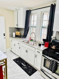 a kitchen with white cabinets and a sink and a stove at Southern Comfort Retreat in Macon