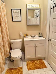a bathroom with a toilet and a sink and a mirror at Southern Comfort Retreat in Macon