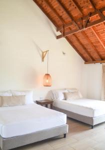 Habitación con 2 camas, paredes blancas y techos de madera. en Hotel Santa Isabel, en Pereira