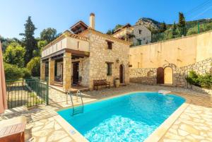 a villa with a swimming pool in front of a building at Villa Maria in Xirokástellon