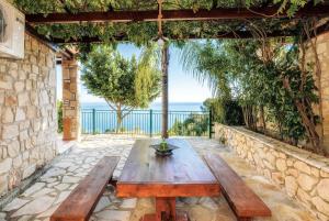 a wooden table on a patio with a view of the ocean at Villa Maria in Xirokástellon