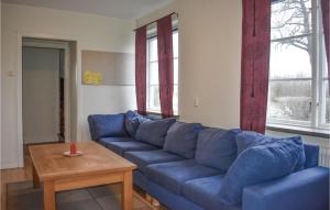 a blue couch in a living room with a table at 7 Bedroom Awesome Home In Tomelilla in Tomelilla
