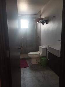 a bathroom with a toilet and a sink and a window at lindo y cómodo departamento familiar in Mexico City
