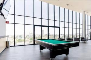 a pool table in a large room with windows at Moderno Bien Ubicado , Piscina A97c in Guadalajara