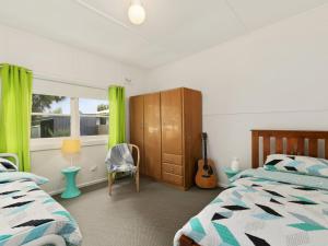 a bedroom with two beds and a guitar in it at Vintage Sunrise in Inverloch