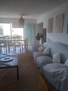 uma sala de estar com um sofá e uma mesa em Sierras de Paz em Villa Giardino