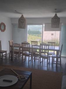 een eetkamer met een tafel en stoelen en een raam bij Sierras de Paz in Villa Giardino