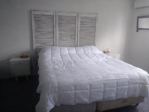 a bedroom with a white bed and a window at Sierras de Paz in Villa Giardino